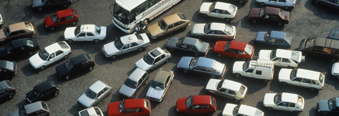 Cars, trucks and busses crammed together at a block intersection
