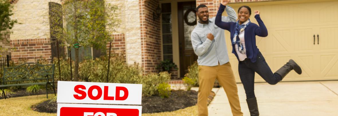 Black man and woman jump for joy after buying new home