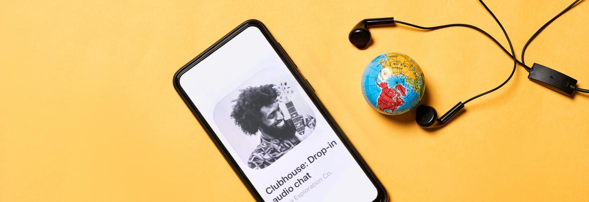 Mobile phone with clubhouse app, small globe and earbuds
