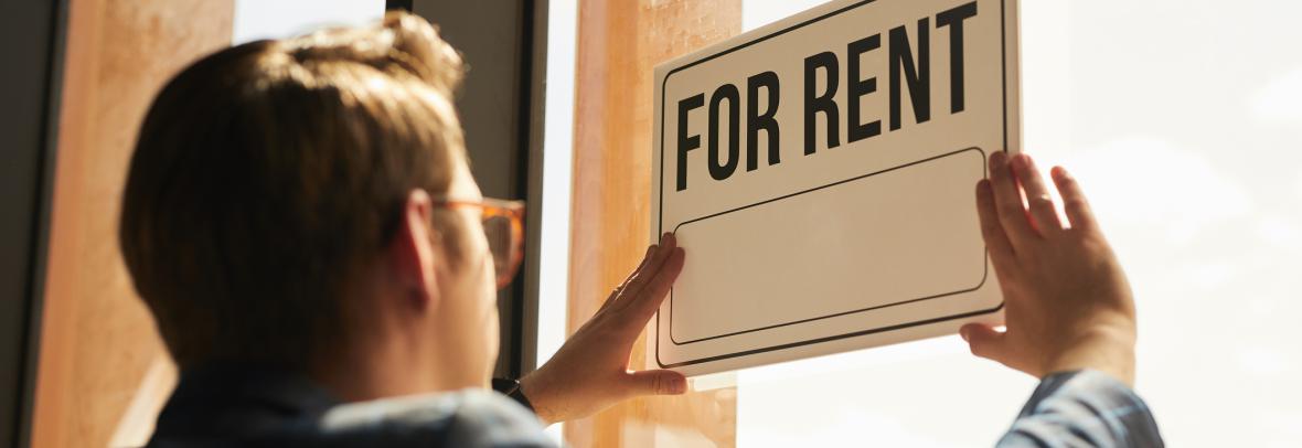 Many hangs a for-rent sign in his window