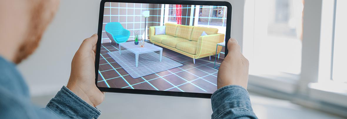 Photo of a man looking at a virtual rendering of a living room on his tablet