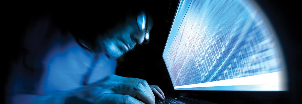 Photo of a man looking ominously at computer