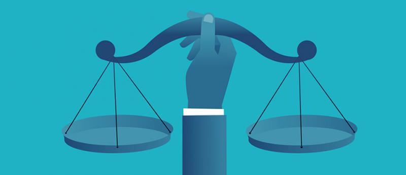 Illustration of the scales of justice being held my a person's hand