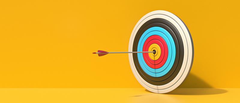 Photo illustration of a target with an arrow in it on a yellow background