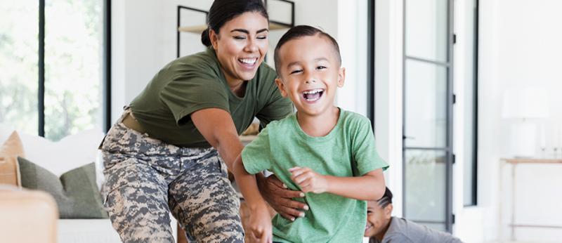 Photo of a military mom playing with her child, laughing