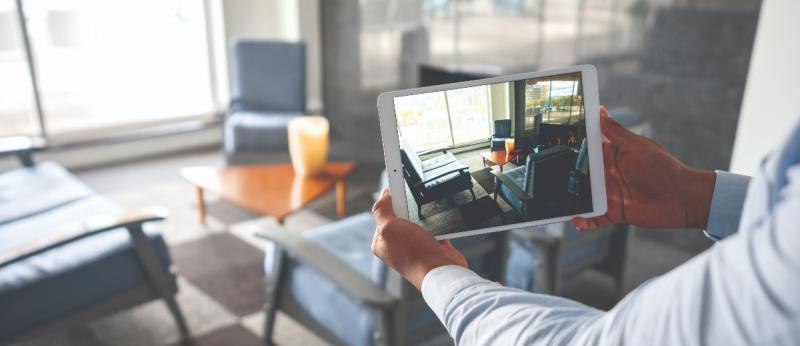 man holding ipad shooting video of a living room