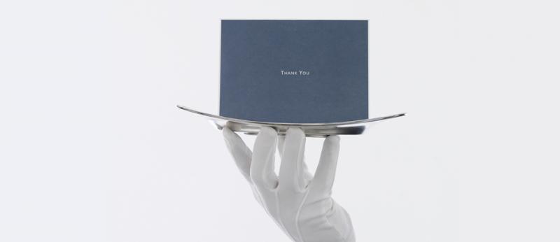 image of a white gloved hand holding a silver platter