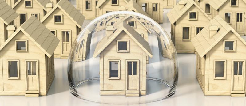 Small models of homes; the center one is covered in a bubble