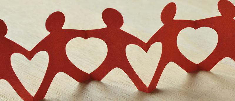 paper cut outs of people holding hands creating heart shapes in between