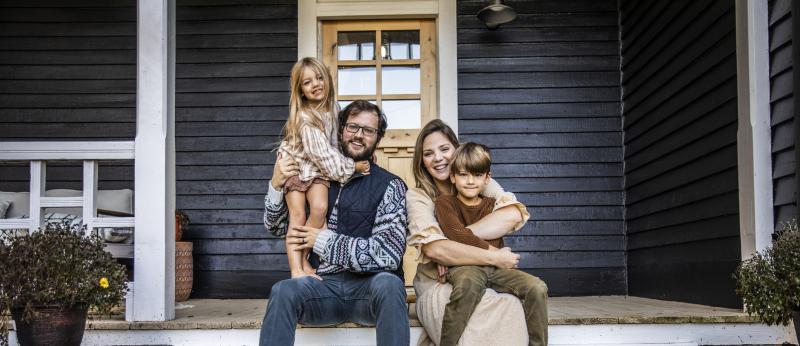 Couple with two young children sitting on front porch