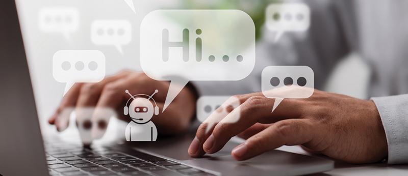 Photo of a persons hands on a computer keyboard and little white chatbot saying Hi