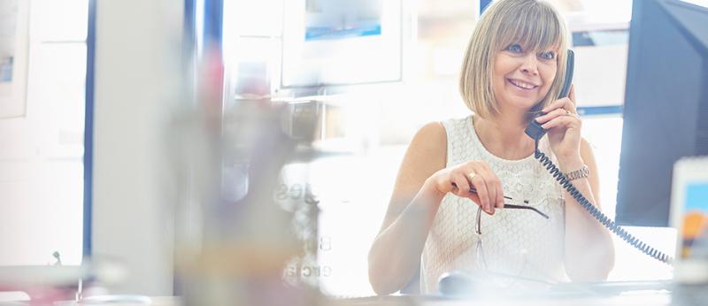 Photo of a female realtor at her desk on the phone