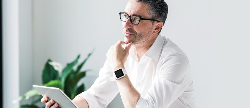 Photo of a business man thinking with tablet in hand