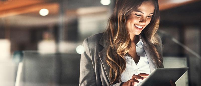Photo of a business using a tablet and smiling