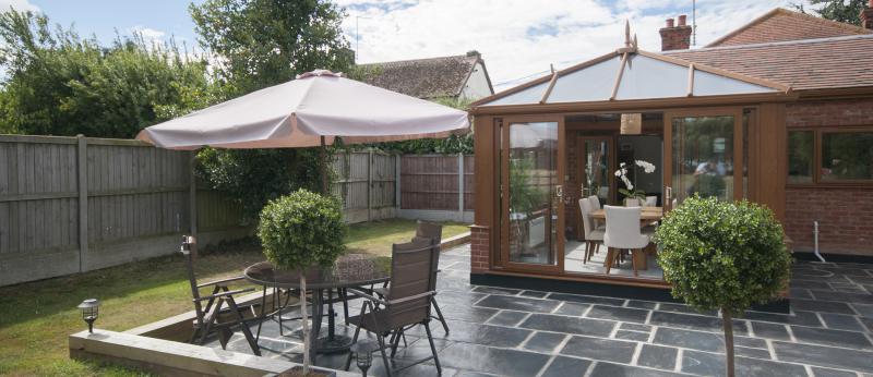 Small ADU home sits along a slate patio with table and chairs nearby
