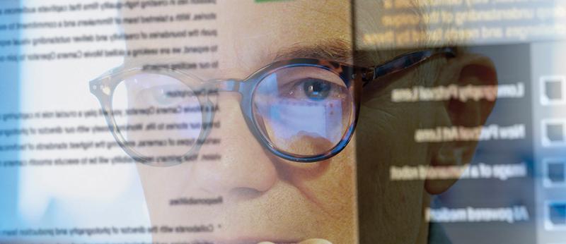 Photo of a man looking at a computer screen with words on it