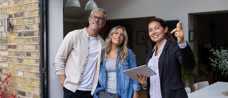Photo of a realtor showing a property to a couple