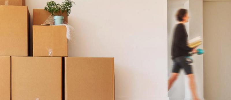 women walking past doorway and moving boxes