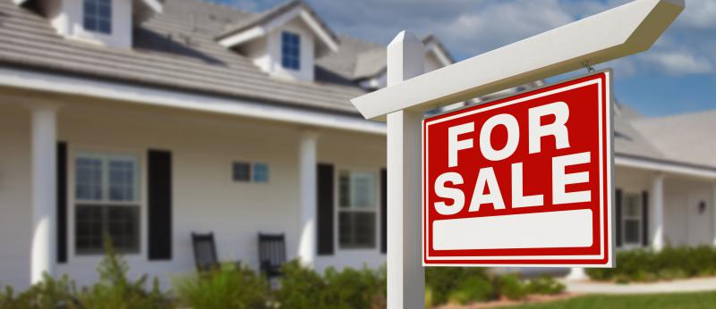 For Sale sign in front of pretty white house