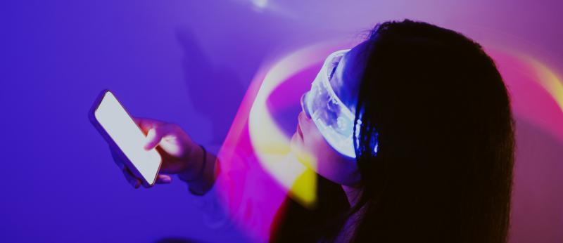 photo illustration of woman holding cell phone with light wrapped around her face and eyes