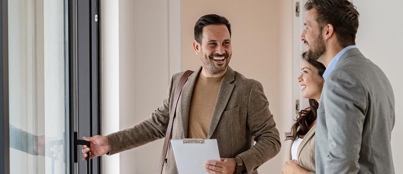 Male real estate agent showing a couple a house