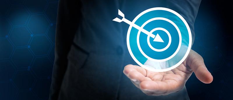 business man holding a target with an arrow in the center
