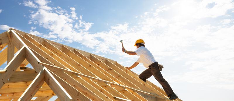construction worker hammering on a roof