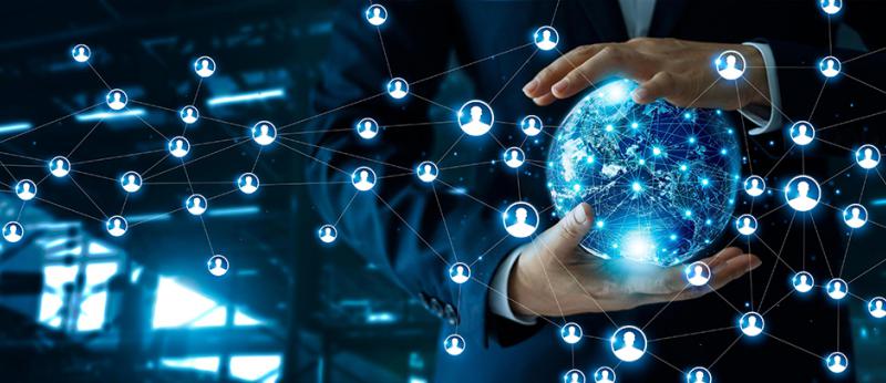 Photo illustration of a business man holding a blue globe with floating people shapes 