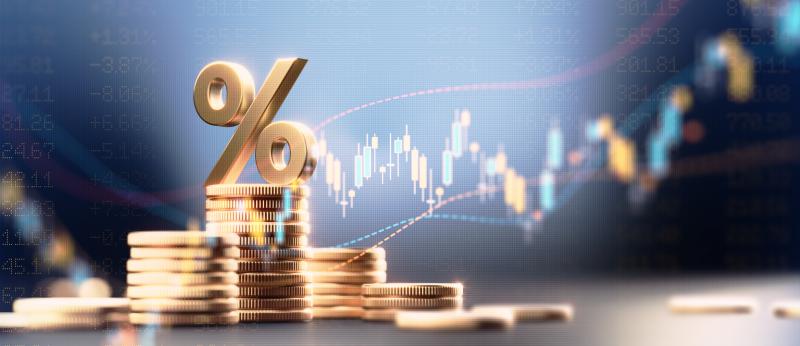 Percentage sign on top of coin stacks before blue financial graph. Horizontal composition with copy space. Business and finance concept.