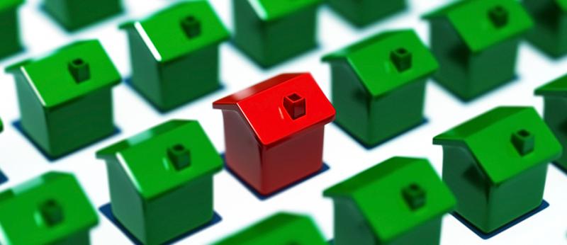 photo of many green toy houses with one highlighted in red