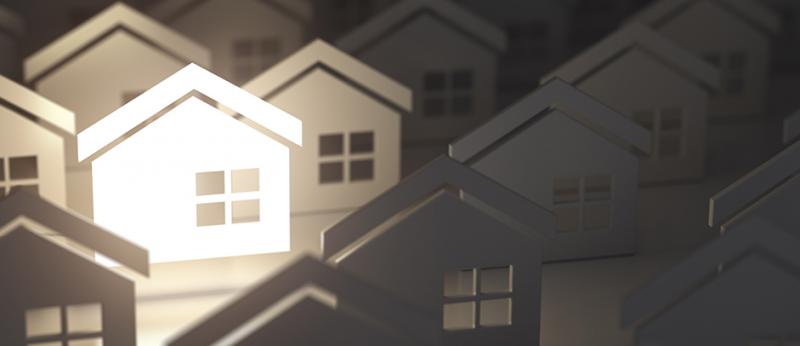 illustration of many house cutouts with one illuminated in white