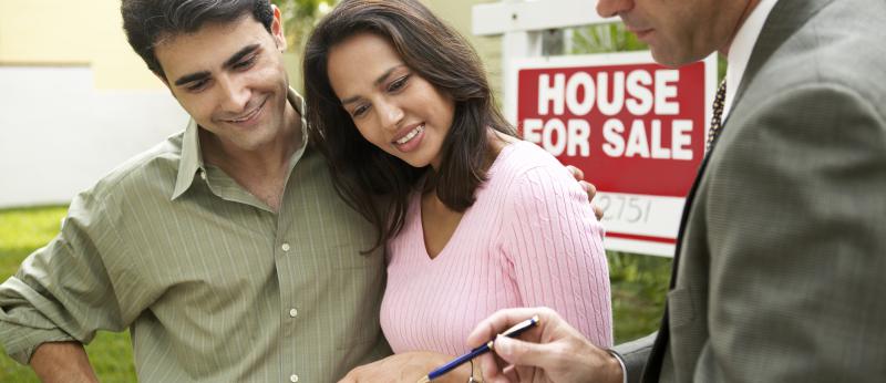  Couple and Real Estate Agent signing papers for new house