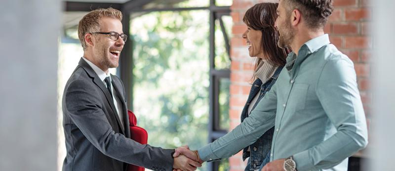 Real Estate agent shaking hands with a couple