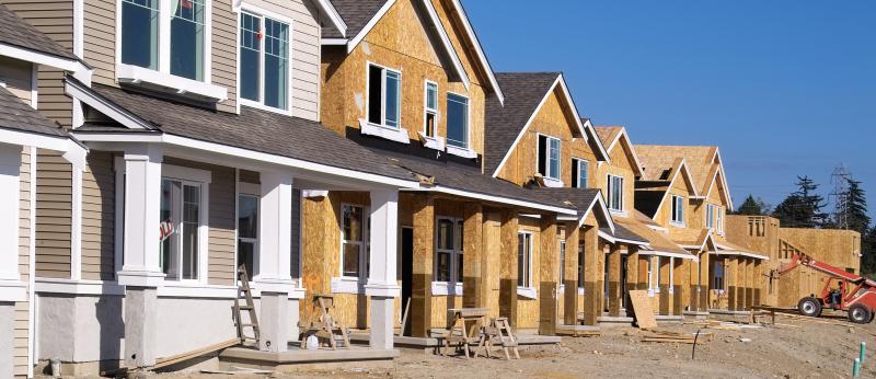 Housing Development Under Construction - stock photo  Perspective photo of a row of similar style houses during various phases of construction.