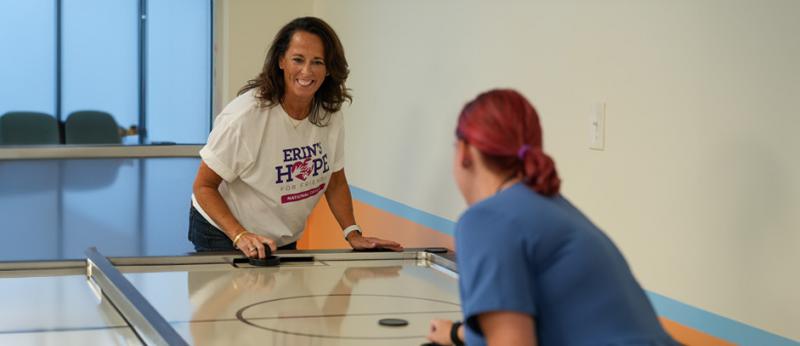 Stacy Horst plays table hock with a young adult 