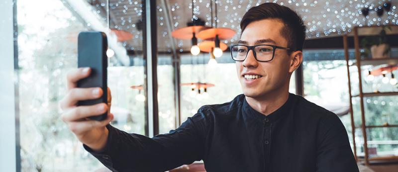 Photo of a man taking video with his phone