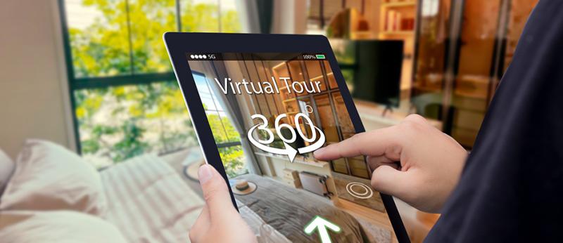 Photo of a person holding a tablet with a virtual tour of a home on the tablet