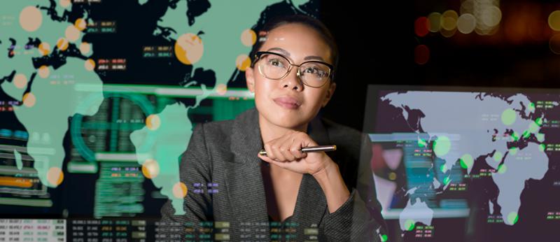 Photo illustration of an asian woman looking up at continents projected on wall