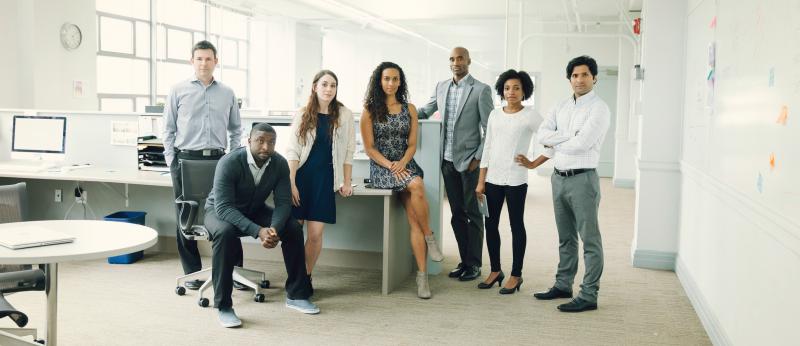 people standing and sitting in an office