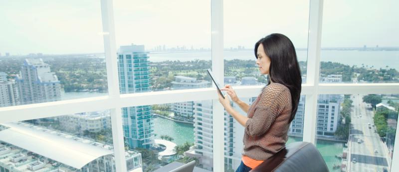 Woman with tablet in office overlooking city skyline