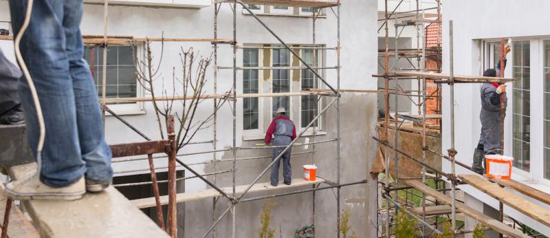 Workers on scaffolding on exterior of a building