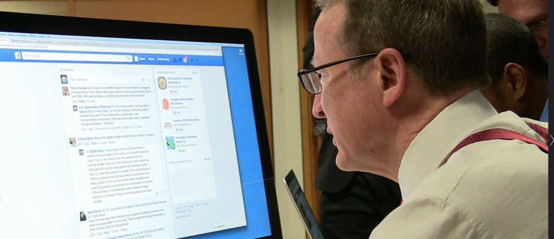 Man at computer looking at Facebook