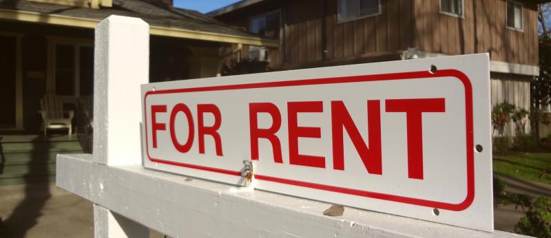 Single-family home with for-rent sign out front