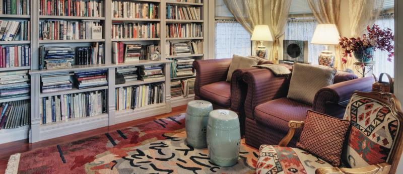 cozy living room with 3 armchairs and full bookcase wall