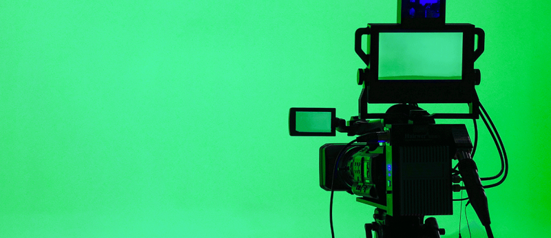 Image of a professional video camera on green background