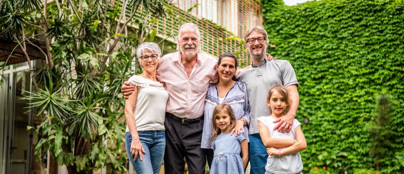 Five people from three generations tand in front of a house