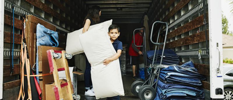 Ten-year old in the back of a moving van helping to unload