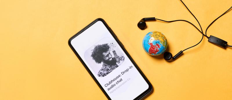 Mobile phone with clubhouse app, small globe and earbuds