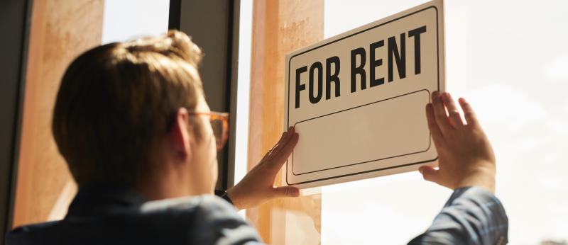 Many hangs a for-rent sign in his window