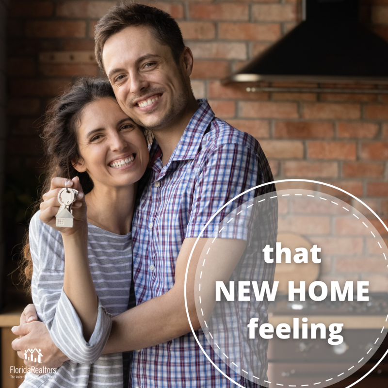 Couple with keys with words "that new home feeling"